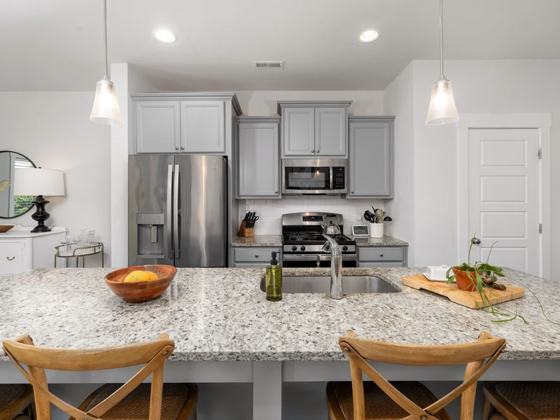 Kitchen with a speckled granite island and white cabinets