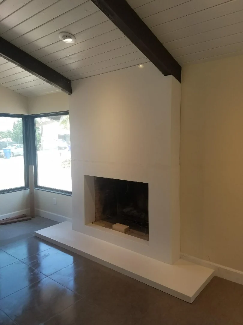 White stone fireplace surround with a raised hearth